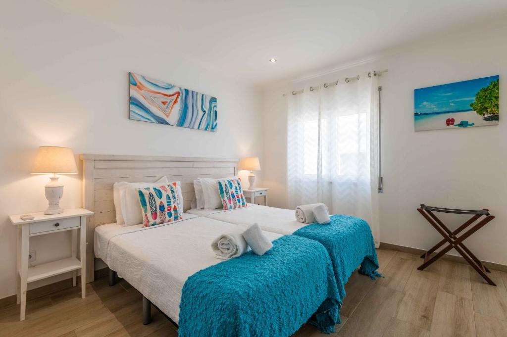 una camera con due letti con lenzuola blu di Casa Mar d'Alma ad Albufeira