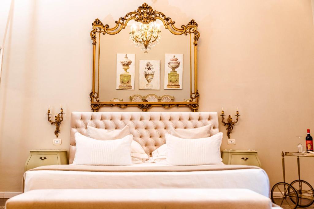 una camera da letto con un grande specchio d'oro sopra un letto di B&B Palazzo Cerami a Catania