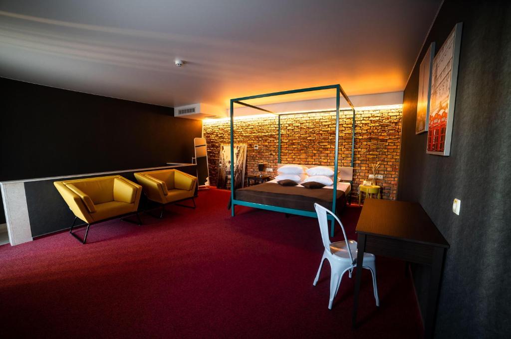 ルツカイにあるSribni Leleky Hotel & Spaのベッド、デスク、椅子が備わるホテルルームです。