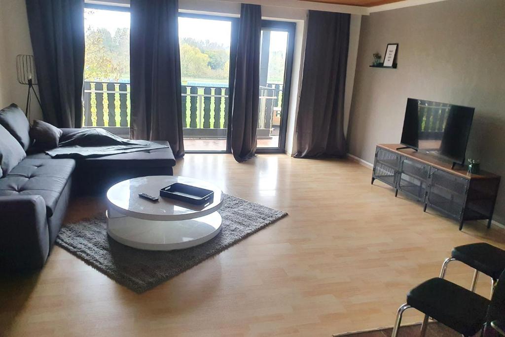 een woonkamer met een bank en een salontafel bij Work & stay apartment with balcony near Ingolstadt in Großmehring