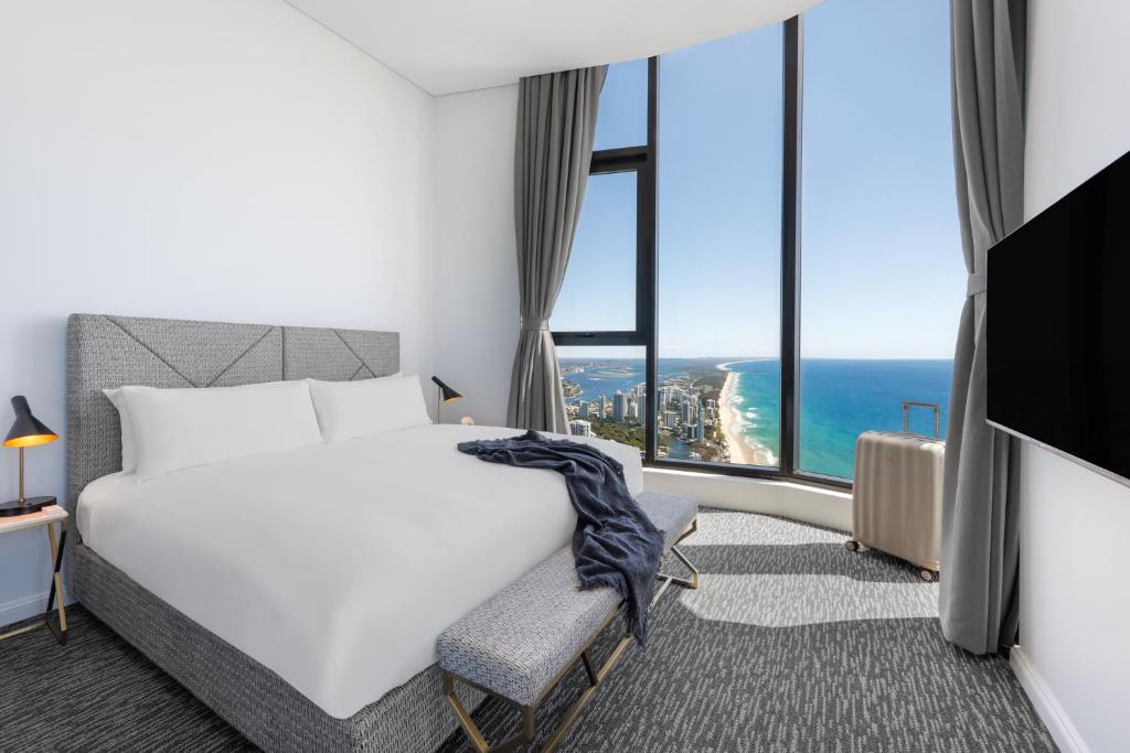 a hotel room with a bed and a view of the ocean at Meriton Suites Surfers Paradise in Gold Coast