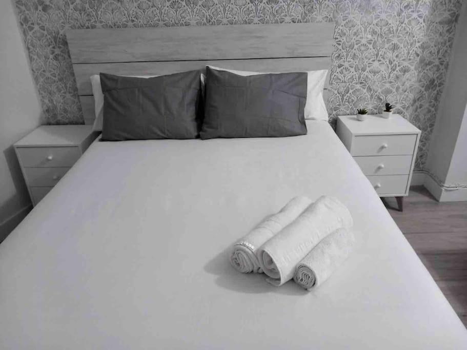マドリードにあるApartamento en el corazón de Madridの白いベッド(タオル2枚付)