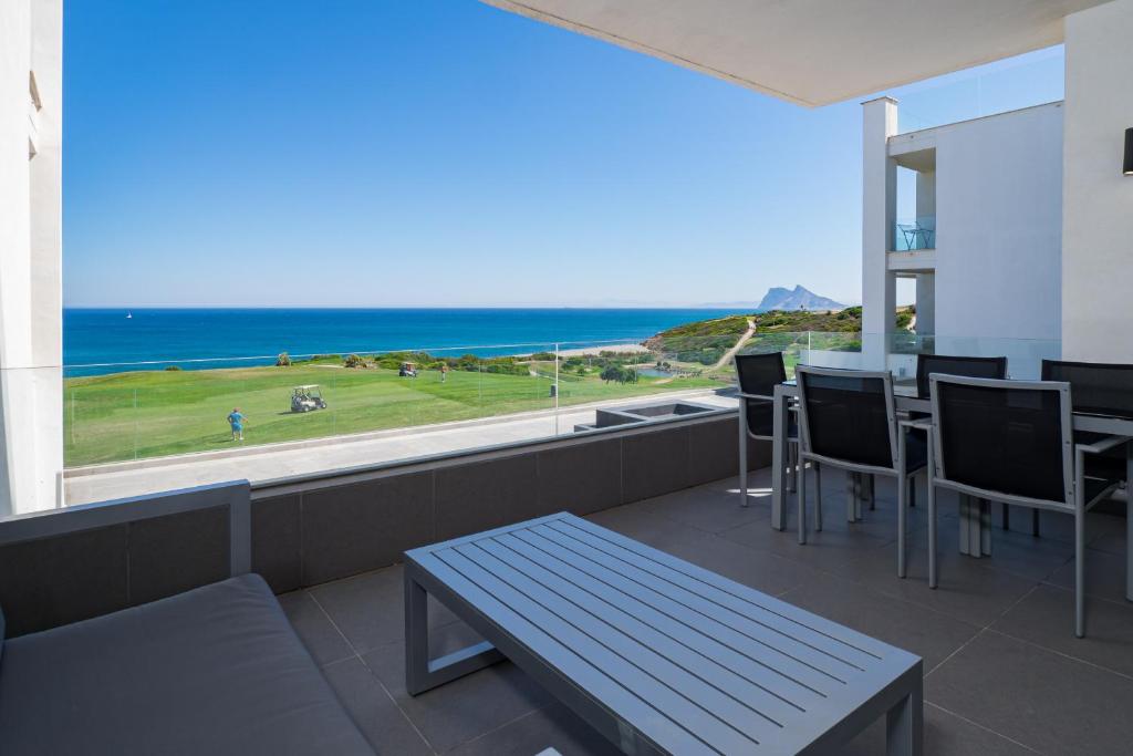 een balkon met een tafel en stoelen en uitzicht op de oceaan bij 2226-Luxury sea view apartment in Alcaidesa