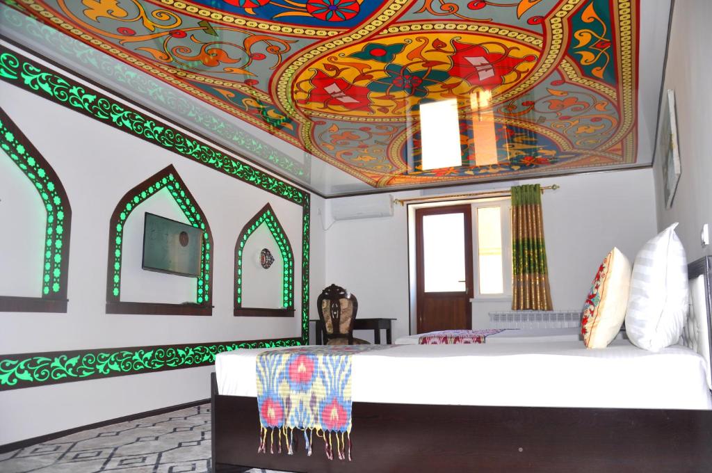 - une chambre dotée d'un plafond recouvert d'œuvres d'art colorées dans l'établissement Khiva Tosh Darvoza, à Khiva