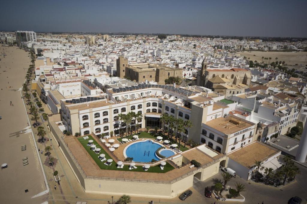 eine Luftansicht auf eine Stadt mit einem großen Gebäude in der Unterkunft Hotel Duque de Najera in Rota