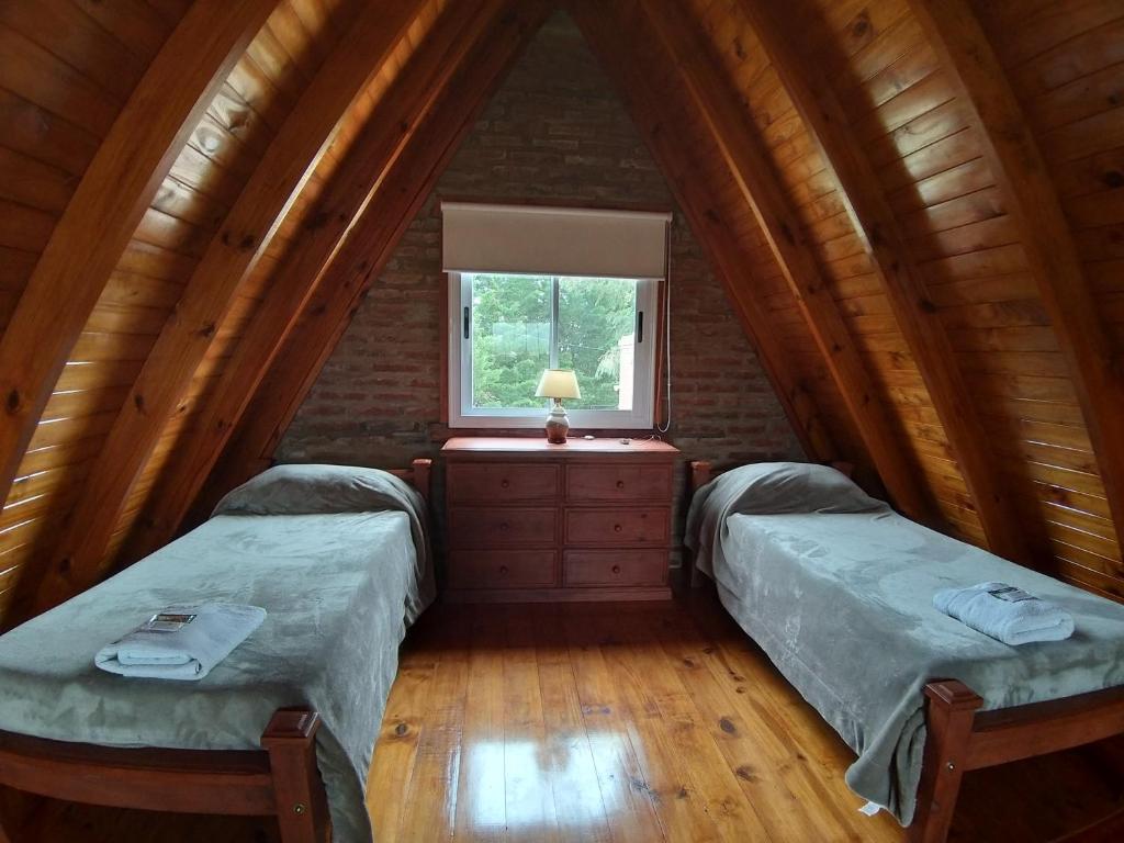 2 camas en un ático con ventana en Cabañas La Esperanza en Tornquist