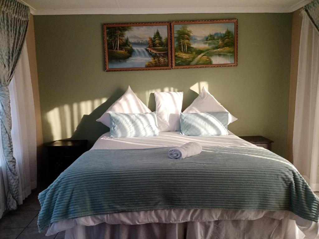 Jubie's Guest Lodge في فيرينجنغ: غرفة نوم مع سرير مع منشفة أرجوانية عليه