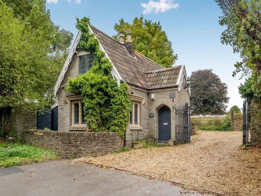 uma velha casa de pedra com uma entrada em frente em luxury 2 bed cosy cottage with hot tub and childrens play area hambrook Bristol em Bristol