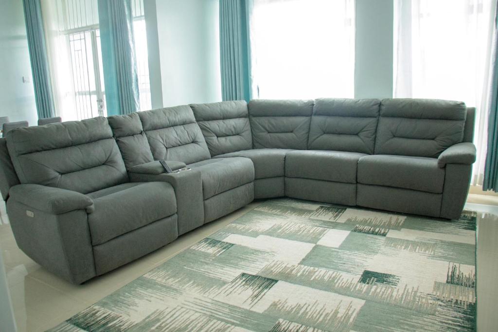 a gray couch in a living room with a rug at Zoe Homes 1br and 2br Apartment Greypoint 406 in Kericho