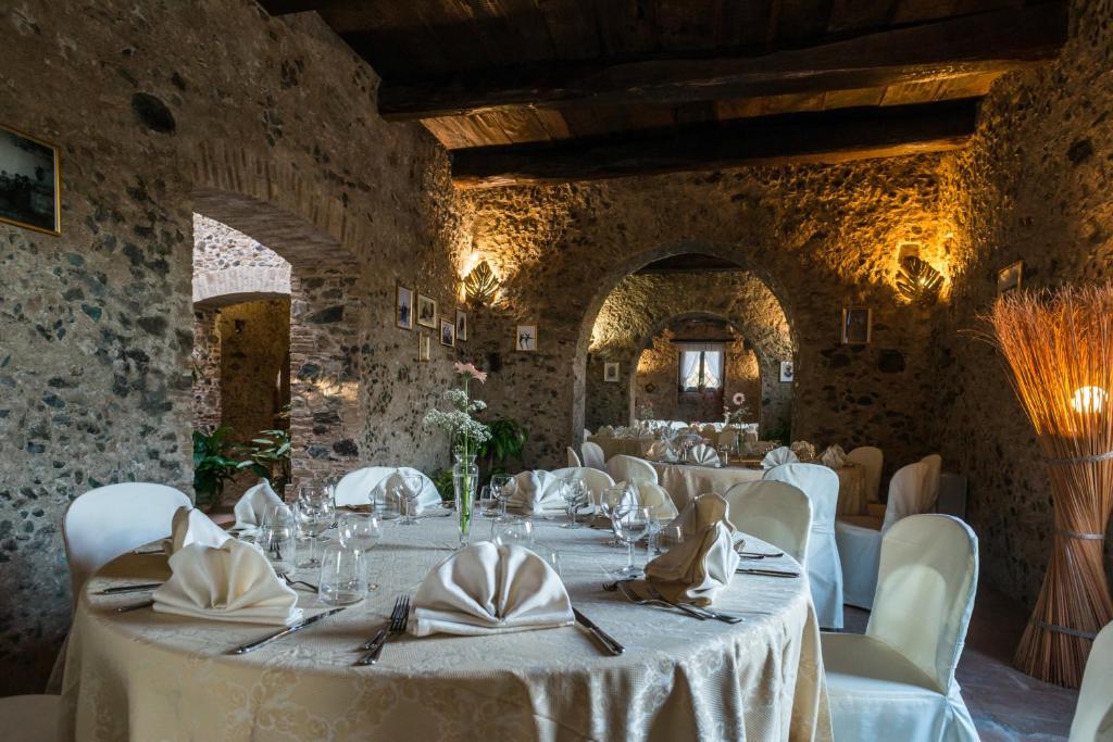 une salle à manger avec une table et des nappes blanches dans l'établissement Agriturismo Piano del Monaco, à Marcellinara