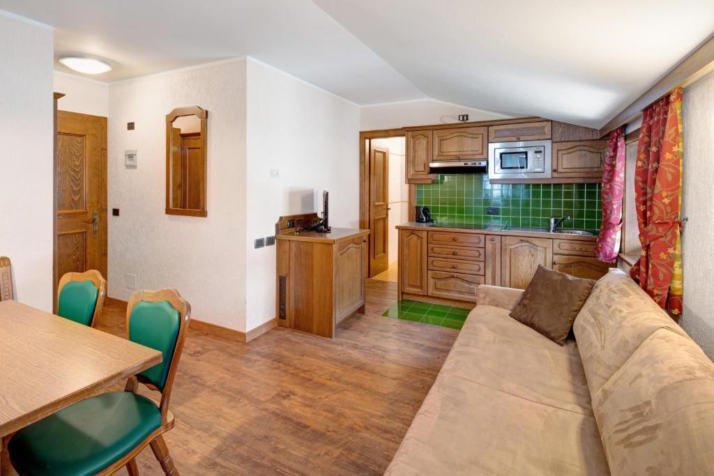 a living room with a couch and a kitchen at Casa San Marco n 8 in Livigno