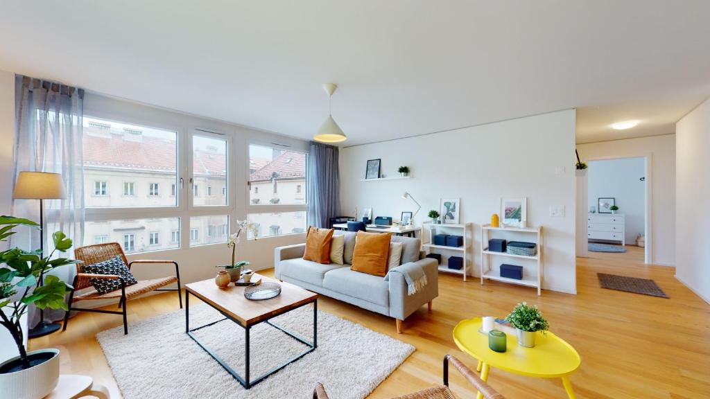 a living room with a couch and a table at Sublime contemporary apartment in the city centre in La Chaux-de-Fonds