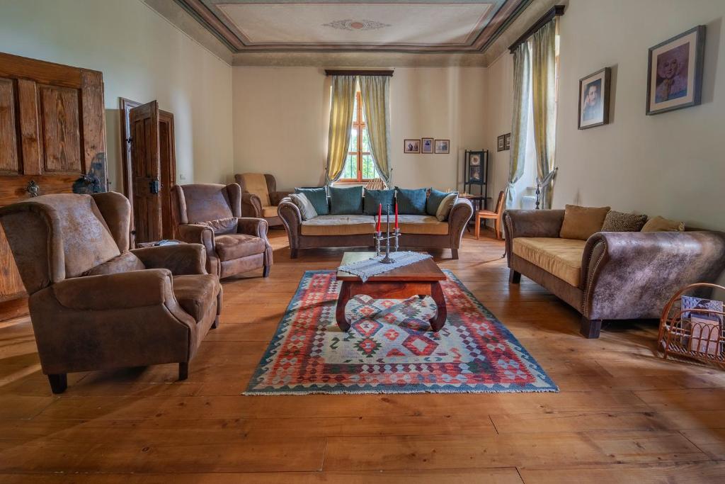 a living room with couches and a coffee table at Conacul Gaal Kuria in Dalnic