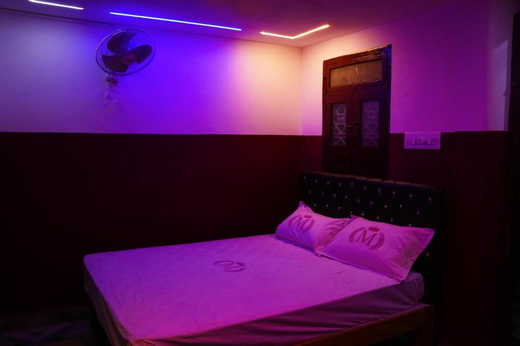 a room with a bed with a pink light at PARI MUTHU VILAS in Chidambaram