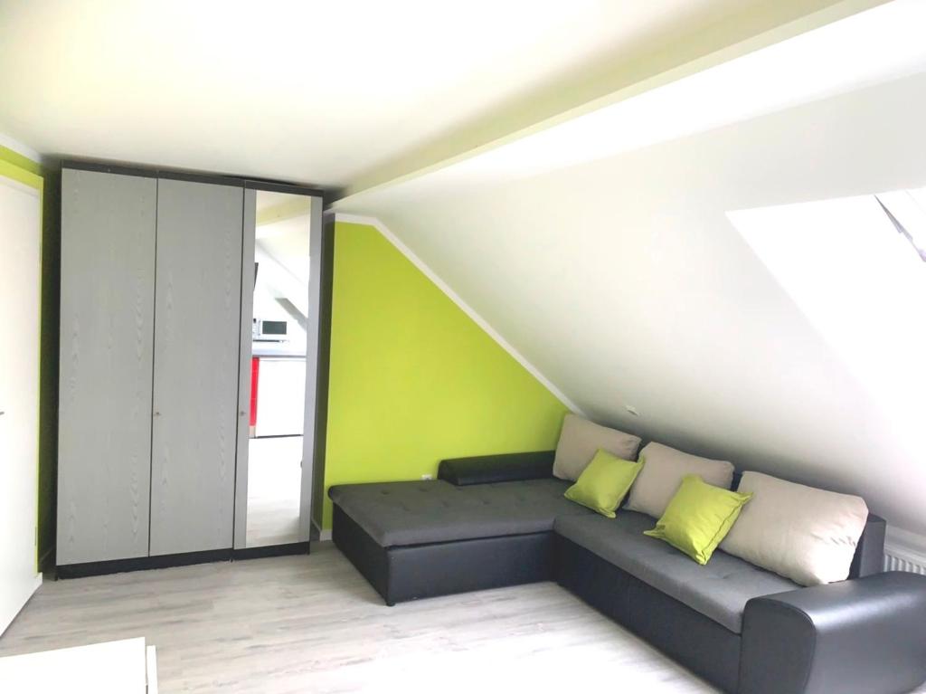 - un salon avec un canapé et un mur vert dans l'établissement Helles Apartment in Berlin-Mariendorf, à Berlin
