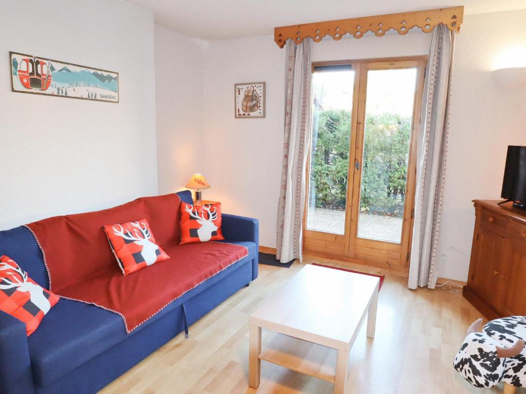uma sala de estar com um sofá azul e uma porta de vidro deslizante em Appartement Samoëns, 2 pièces, 5 personnes - FR-1-624-102 em Samoëns