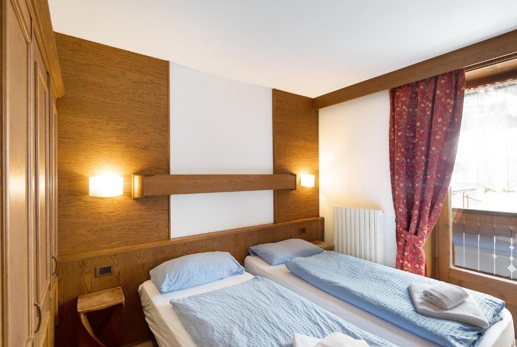 a bedroom with two beds and a window at Casa San Marco n 9 in Livigno