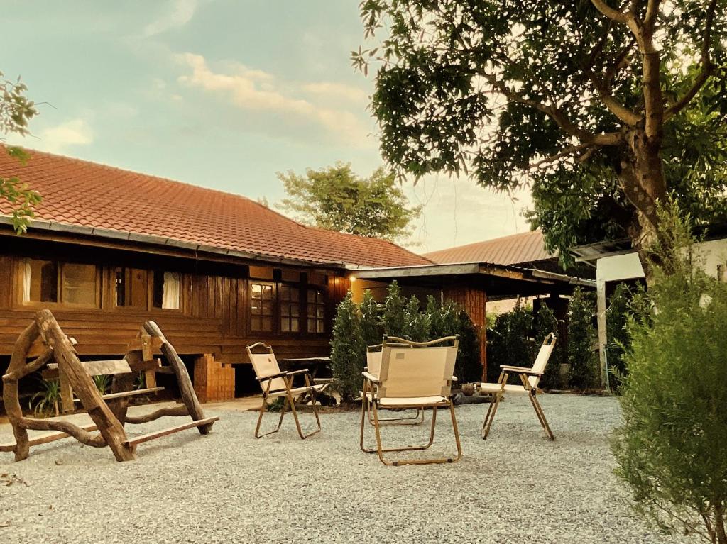 a group of chairs sitting in front of a house at วังภูไพร ฟาร์มสเตย์ in Wang Nam Khieo