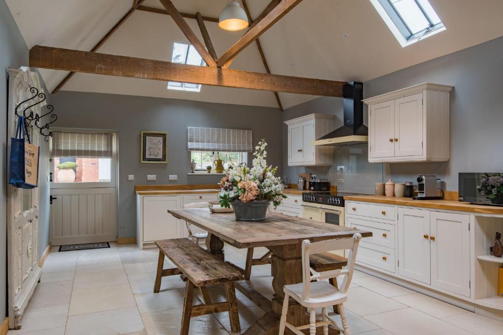 a kitchen with a wooden table and some chairs at The Dairy by Bloom Stays in Ulcombe