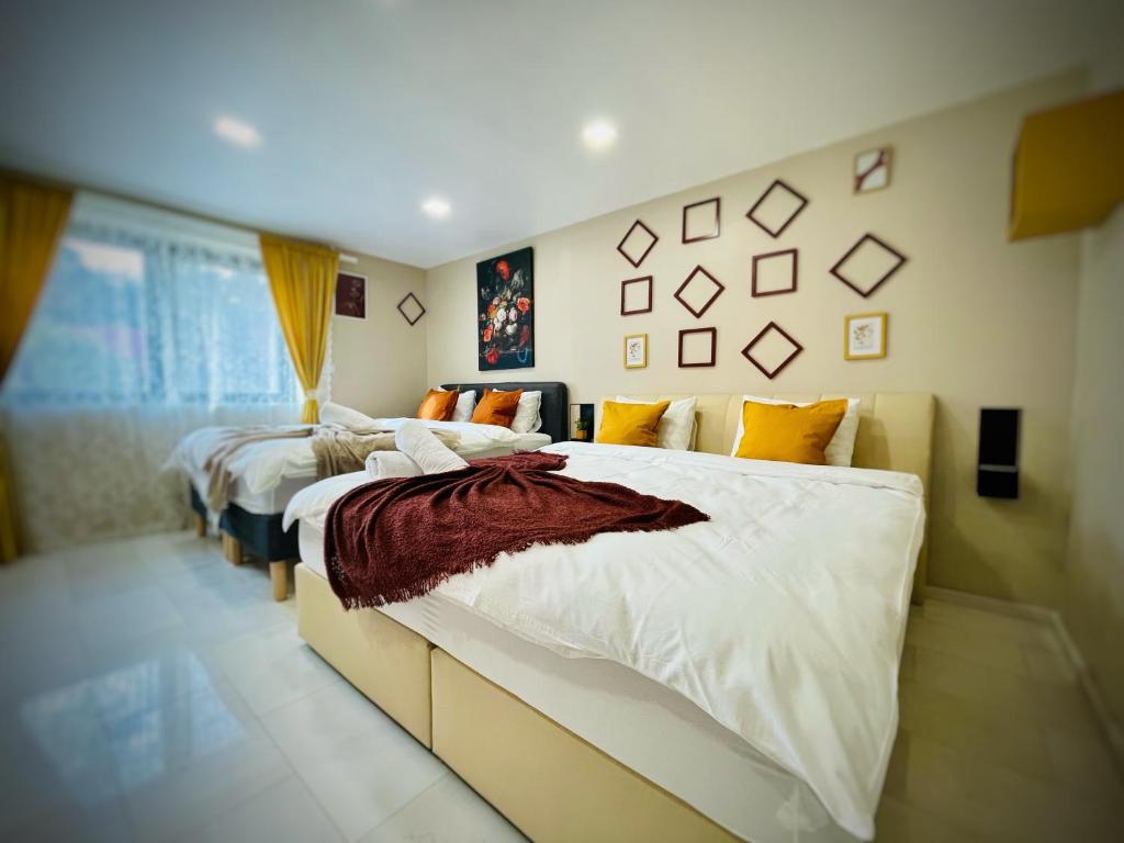 1 dormitorio con 2 camas con sábanas blancas en Montana Family Villa, en Văliug