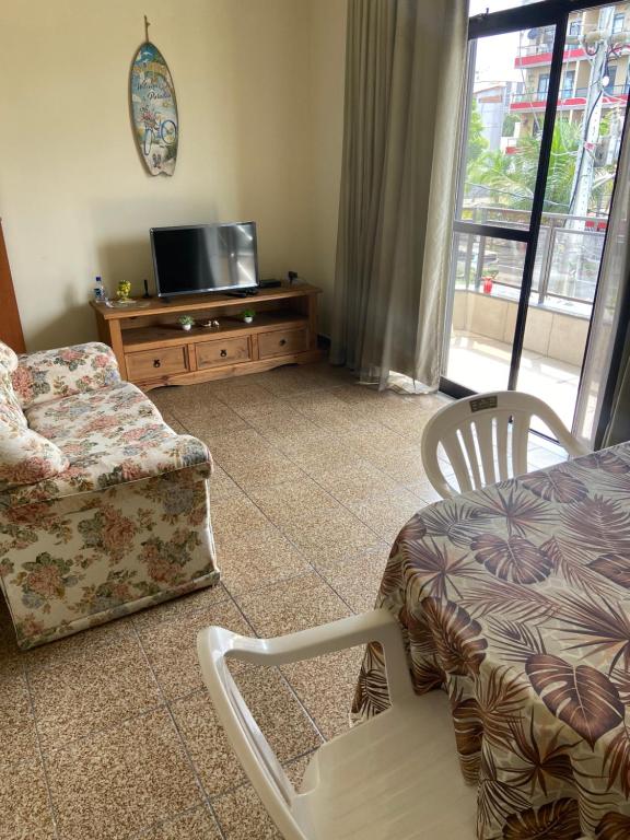 een woonkamer met een bank, een stoel en een tv bij Apartamento CF BRAGA in Cabo Frio