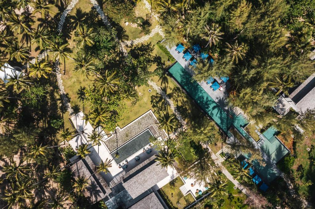 una vista sul parco con palme e piscina di Avani Plus Khao Lak Resort a Khao Lak