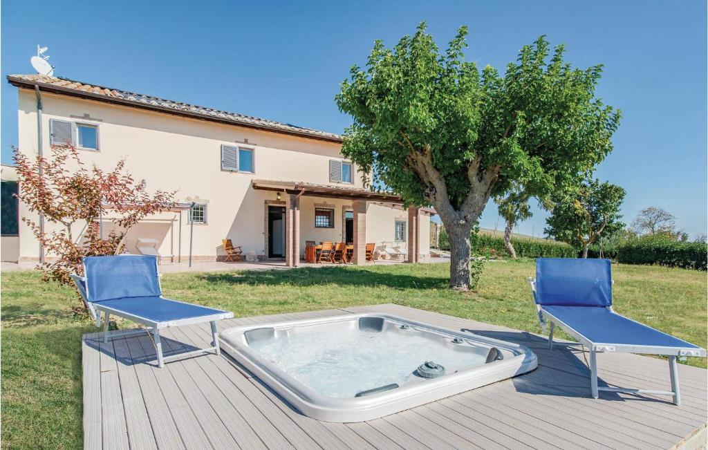 Un jacuzzi sentado en una terraza con dos sillas. en Aurora, en Orciano di Pesaro