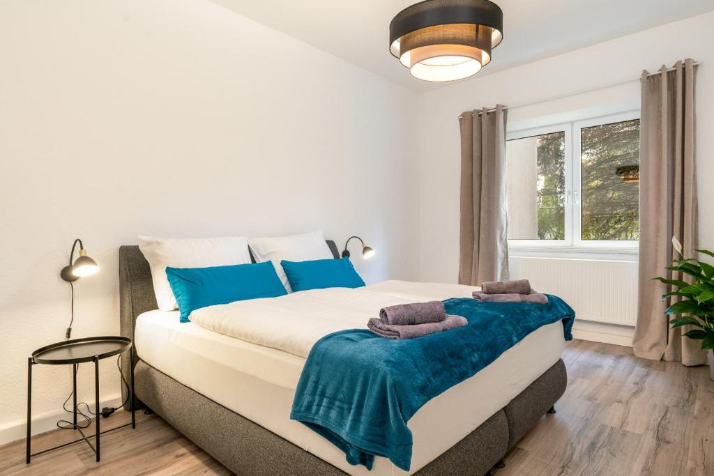 una camera da letto con un grande letto con accenti blu di Modernes Apartment – 2 Boxspringbetten – Zentral a Kassel
