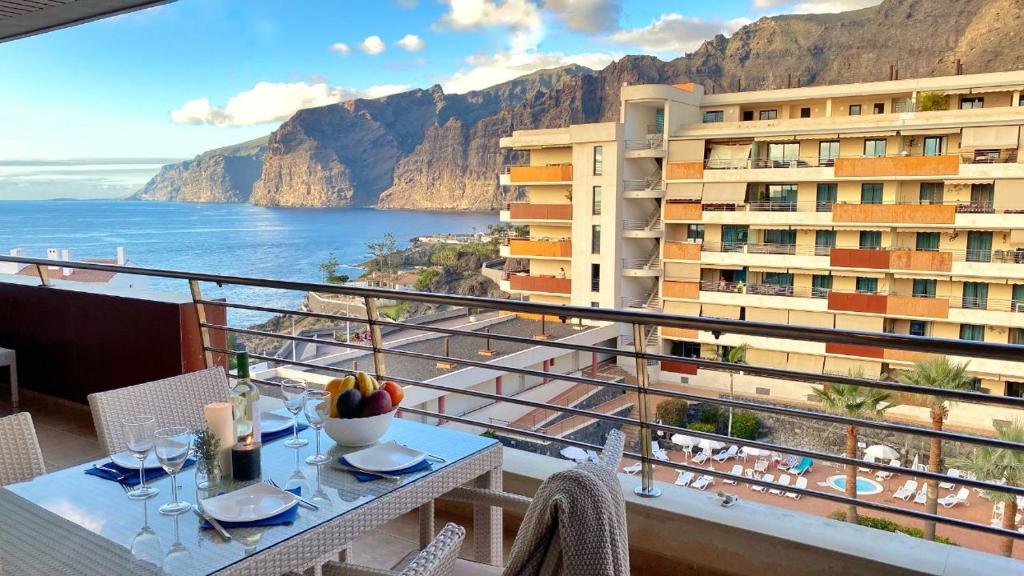 a balcony with a table and a view of the ocean at Balcon De Los Gigantes in Puerto de Santiago