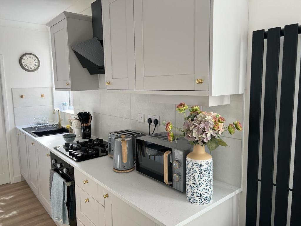 a kitchen with a microwave and a vase with flowers at Somerset House in Northampton