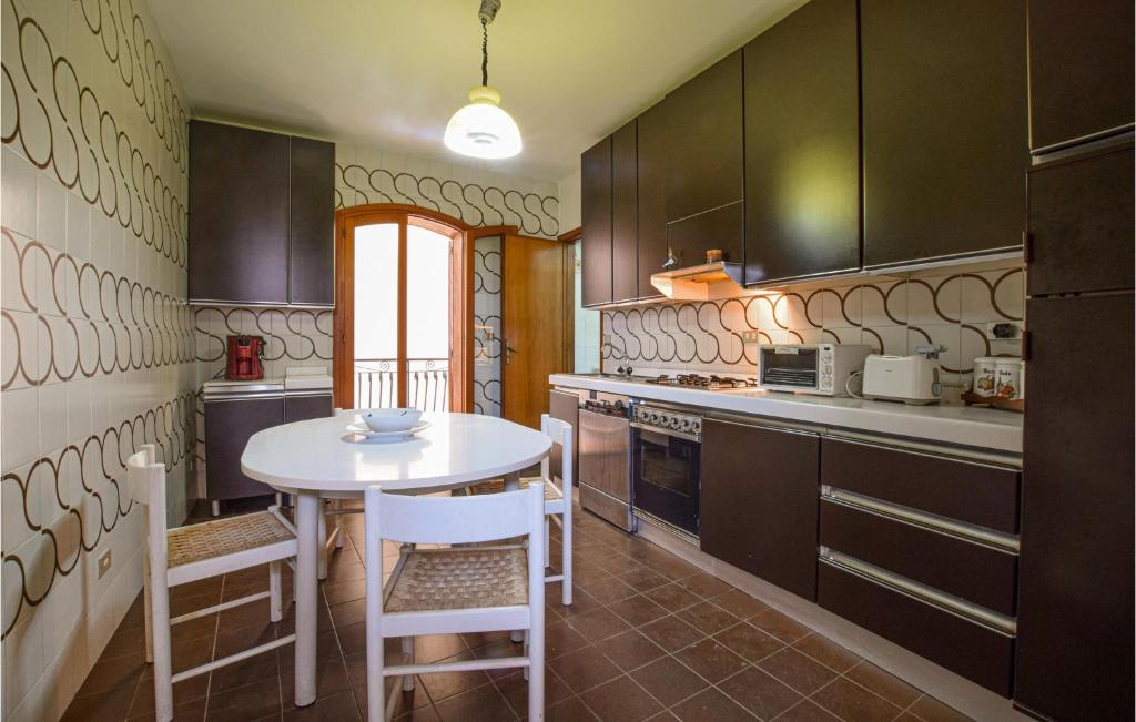 kuchnia z białym stołem i krzesłami w obiekcie Amazing Apartment In Giardini Naxos w mieście Giardini Naxos