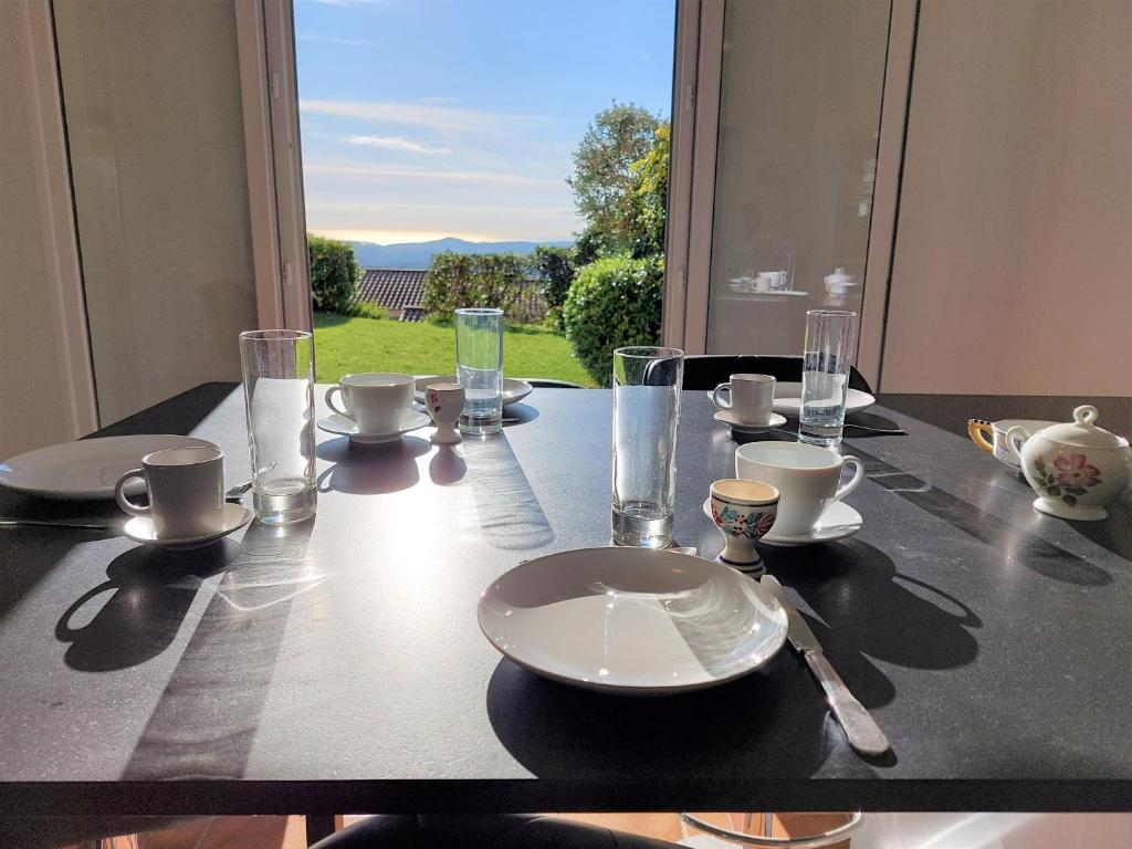 uma mesa com pratos e copos por cima em Maison avec vue imprenable em Châteauneuf