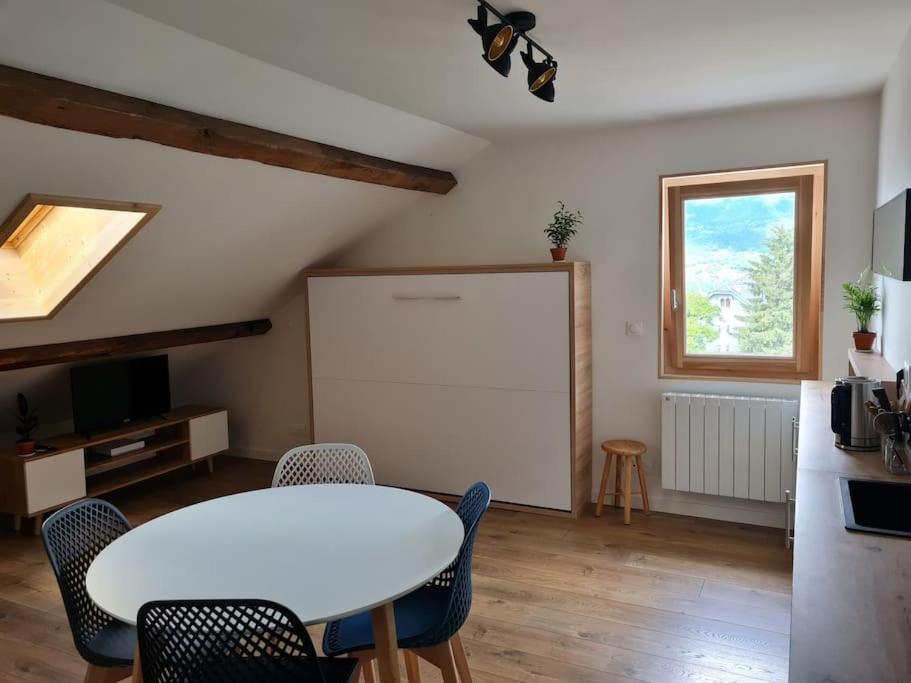a dining room with a white table and chairs at Nid douillet proche des pistes avec vue montagne in Saint-Gervais-les-Bains