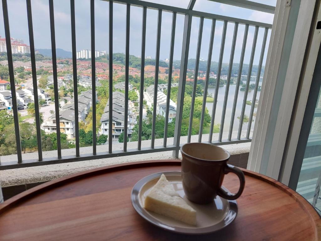 a cup of coffee on a table in front of a balcony at Dlake Putrajaya Homestay in Putrajaya