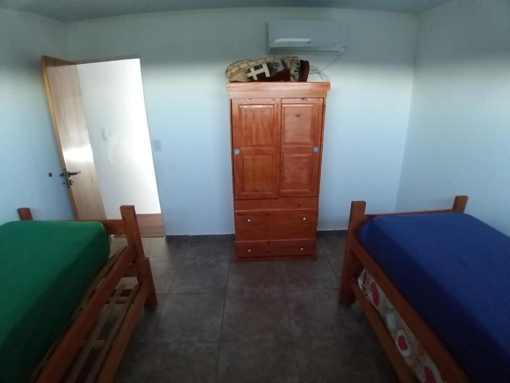 1 Schlafzimmer mit 2 Betten und einer Holzkommode in der Unterkunft Complejo Betesda 1 in Federación