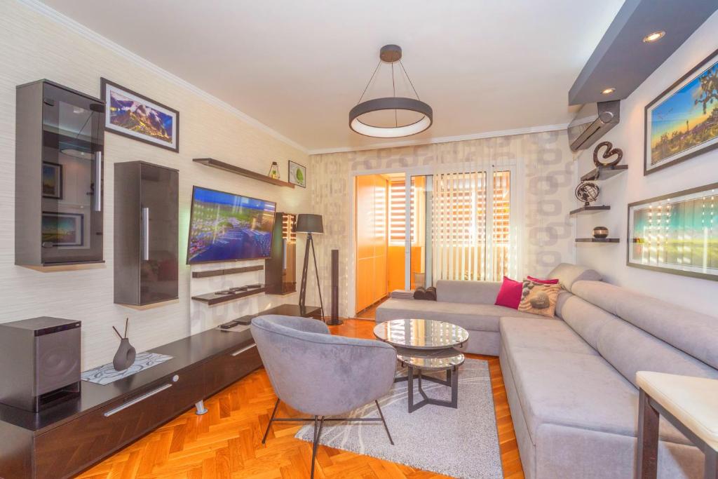 a living room with a couch and a tv at Beni Apartment in Bar