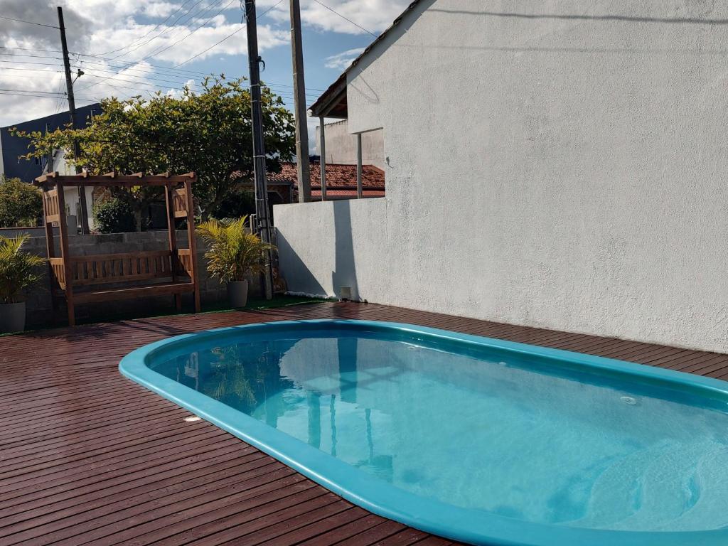 a blue swimming pool on a deck next to a building at casa piscina pinheira -sc in Palhoça