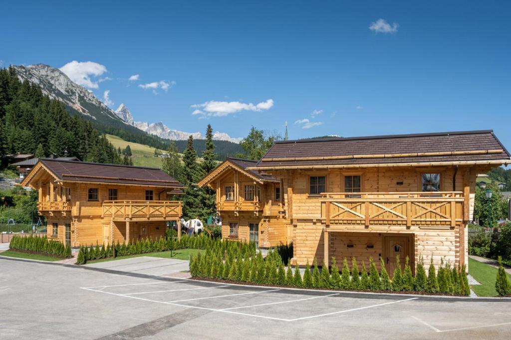 a large wooden house with a parking lot at Dorf-Chalets Filzmoos mit Sauna in Filzmoos