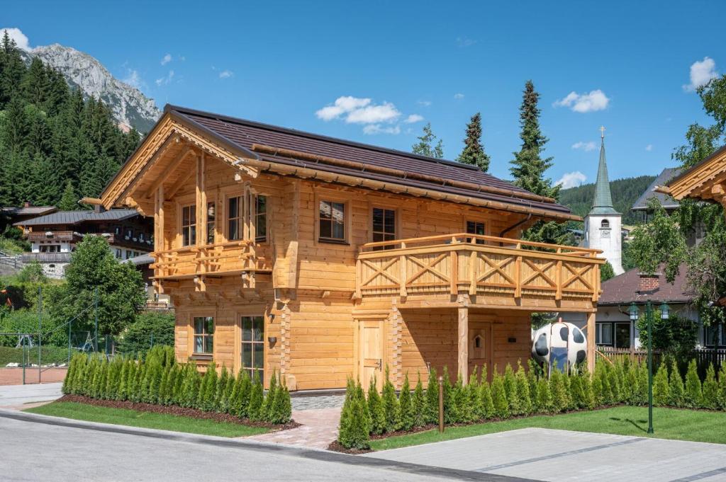 a wooden house with a soccer ball in front of it at Dorf-Chalets Filzmoos mit Sauna in Filzmoos