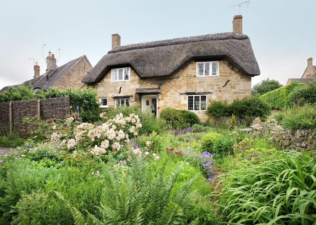 ein Cottage mit einem Garten davor in der Unterkunft Letterbox Cottage in Chipping Campden