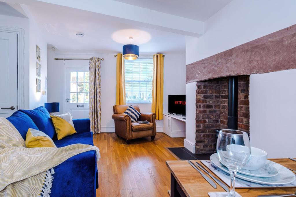 sala de estar con sofá azul y chimenea en Lovely 2-bed house in Chester by 53 Degrees Property, Ideal for Couples & Small Groups, Amazing Location - Sleeps 4 en Hough Green