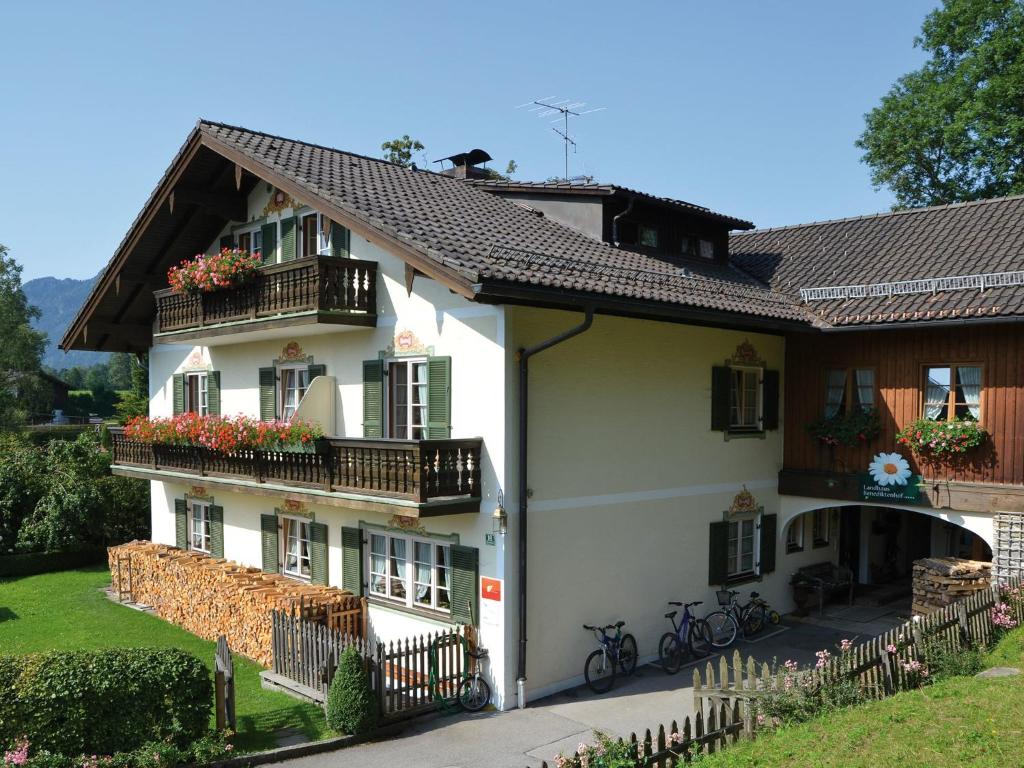 Una casa blanca con balcones y flores. en Landhaus Benediktenhof, en Bad Tölz