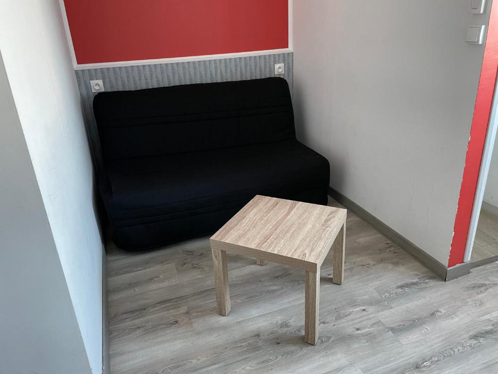 - une chaise noire et une table en bois dans la chambre dans l&#39;établissement Logis Hôtel Le Clement V, à Roquemaure
