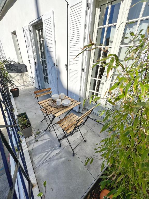 a patio with a table and chairs on a porch at Le Cocon - Coeur de ville in La Rochelle