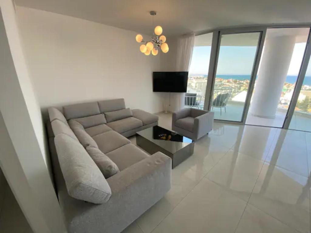 sala de estar con sofá y TV en McKenzie 2 bedrooms Seaview Residence, en Lárnaca