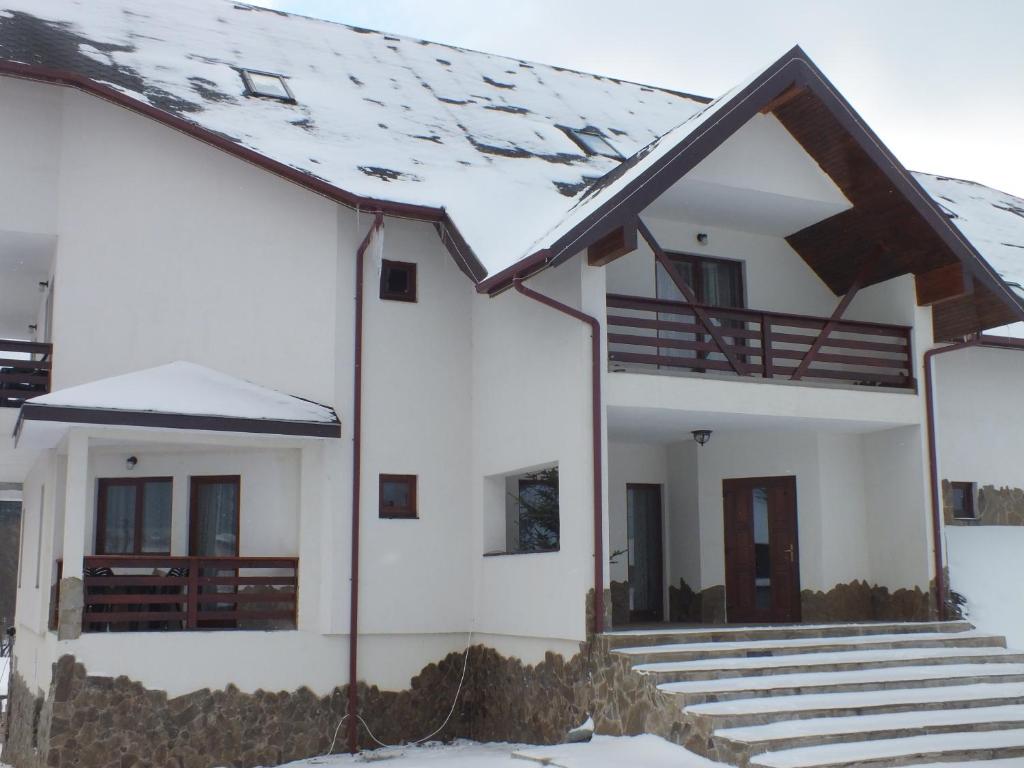 uma casa com neve no telhado em Pensiunea Eliza em Podu Coşnii