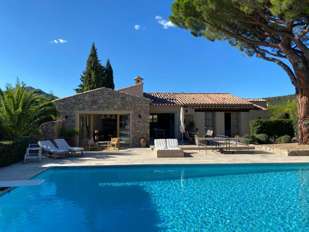 a villa with a swimming pool in front of a house at Lovely "Provence" villa with sea view, private heated pool, airco and beautiful garden in Grimaud