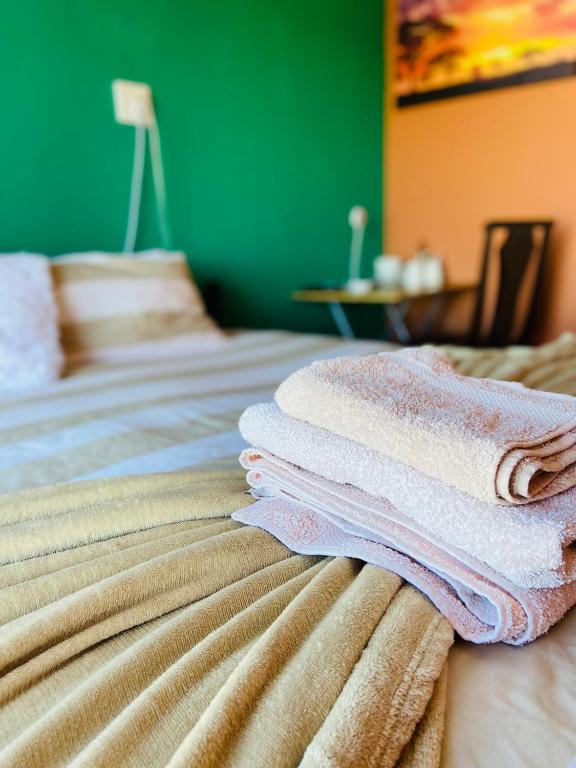 a stack of towels sitting on top of a bed at Village Stay Ngcamngeni in Debe Nek