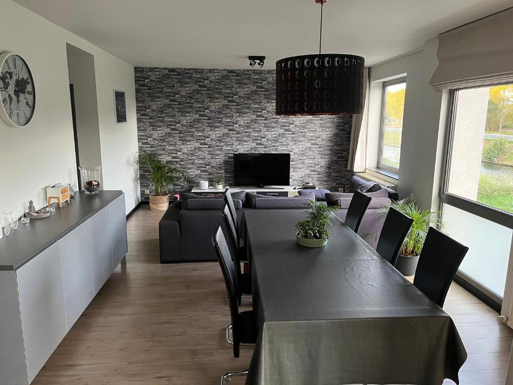a dining room with a table and a couch at Maison Noordburg Veurne in Veurne