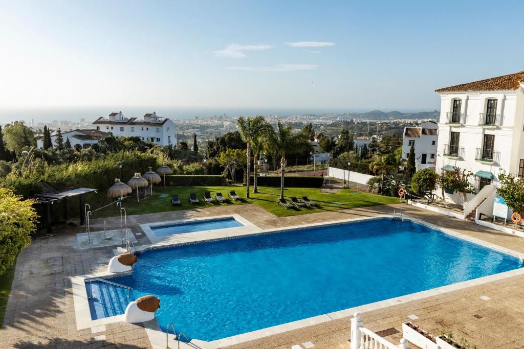 a swimming pool on the roof of a house at Ilunion Hacienda de Mijas in Mijas
